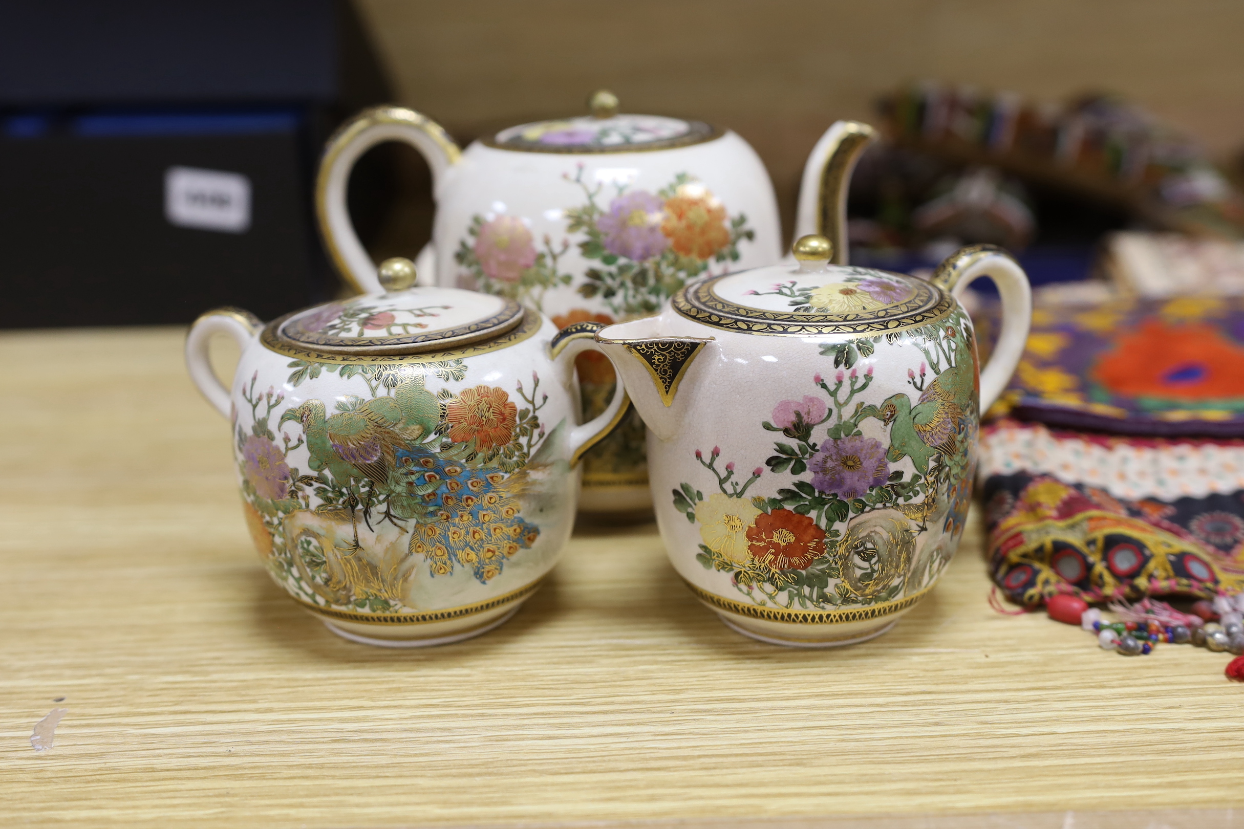 A Satsuma tea service comprising teapot, cream jug, sugar pot, four plates and four cups with saucers